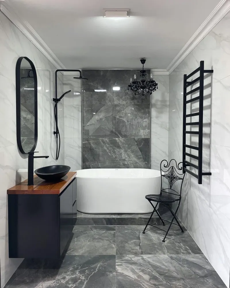 Renovated bathroom with marble-look grey floor tiles, freestanding bath, black tapware and a black heated towel rail