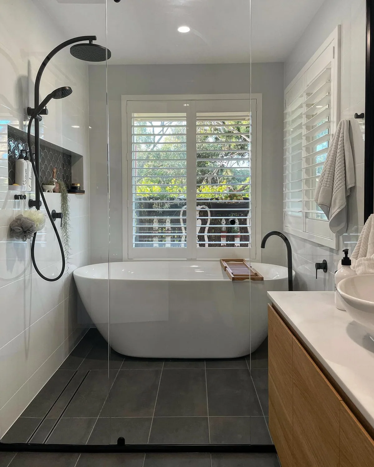 Completed bathroom renovation with freestanding bath, black tapware and precision floor tiling by Becks Bathrooms and Tiling, Adelaide